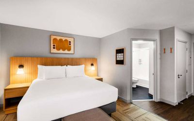 Double bed guest room in Sonesta Simply Suites Austin South, featuring art on the wall and an ensuite bathroom.