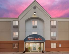 The hotel’s exterior includes potted plants by the front door, above which is the name Sonesta Simply Suites.