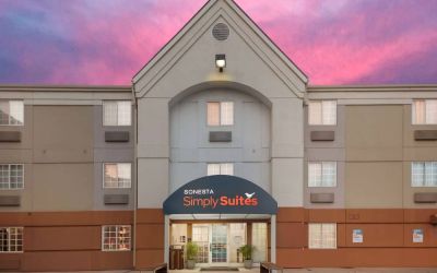 The hotel’s exterior includes potted plants by the front door, above which is the name Sonesta Simply Suites.