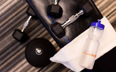 The fitness center at Sonesta Simply Suites Plano Frisco includes free weights and benches for guests to use, plus towels and water.