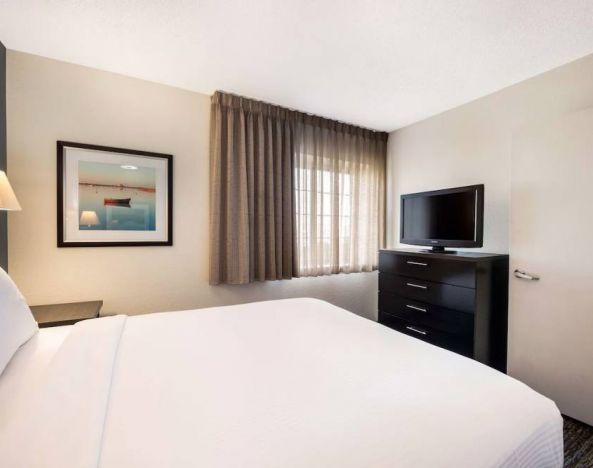 Double bed guest room in Sonesta Simply Suites Dallas Las Colinas, featuring a window and widescreen TV.