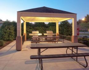 The gazebo at Sonesta Simply Suites Dallas Las Colinas includes barbecue facilities and picnic tables and benches where guests can dine and socialize.