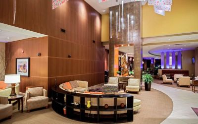 Sonesta Milwaukee West Wauwatosa’s lobby lounge features comfy armchair and sofa seating, a high ceiling, and coffee tables.