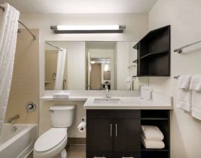 Guest bathroom in Sonesta Simply Suites Hampton, including bathtub, lavatory, mirror, and sink.