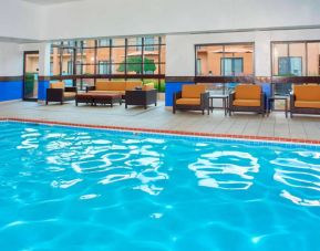 Sonesta Select Detroit Auburn Hills’ indoor pool has armchair and sofa seating by the side, plus large windows.