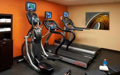 The hotel fitness center has art on the wall and a range of exercise equipment, including treadmills and an elliptical.