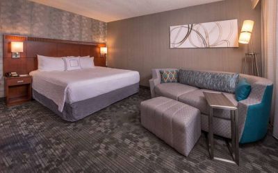 Sonesta Select Columbia double bed guest room, with art on the wall and a sofa.