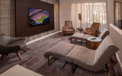 The hotel’s lobby features reclined seats facing a large, wall-mounted TV.