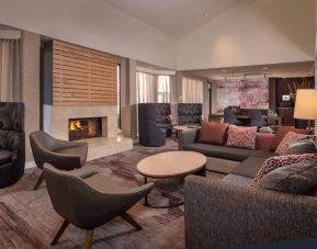 Sonesta Select Columbia’s lobby lounge is furnished with a large sofa and comfy chairs, coffee tables, and a fireplace.