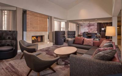 Sonesta Select Columbia’s lobby lounge is furnished with a large sofa and comfy chairs, coffee tables, and a fireplace.