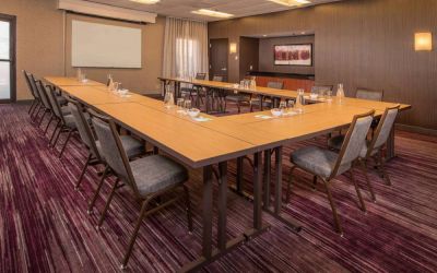 Meeting room in Sonesta Select Columbia, with tables arranged in a U-shape, seating for over a dozen attendees, and a whiteboard.