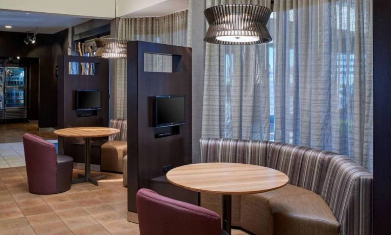 Sonesta Select Indianapolis Carmel’s media pods each feature a TV, coffee table, and comfortable seating next to a window.