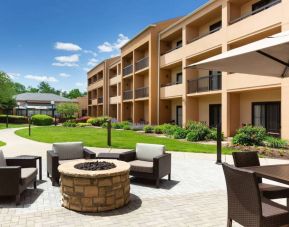 The hotel fire pit has comfy armchairs around it, with a shaded table and chairs nearby.