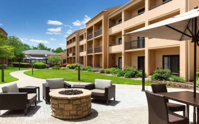 The hotel fire pit has comfy armchairs around it, with a shaded table and chairs nearby.