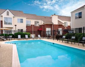 Sonesta ES Suites Annapolis’ outdoor pool has a shaded table and chairs, loungers, and chairs by the side.