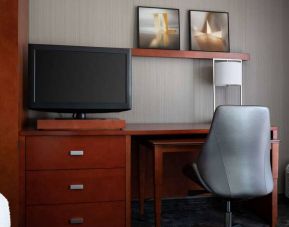 Sonesta Select Phoenix Camelback guest room workspace, including desk, chair, and lamp, plus a TV.