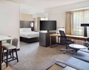 Double bed guest room in Sonesta ES Suites Raleigh Cary, featuring TV and sofa, plus workspace desk, chair, and lamp.