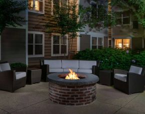 Sonesta ES Suites Fairfax Fair Lakes’ fire pit has armchairs, coffee tables, and a sofa where guests can relax and socialize.