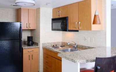 Sonesta ES Suites Dallas Medical Market Center guest room kitchen, with microwave, fridge-freezer, and hob.