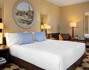 Royal Sonesta Chicago River North double bed guest room, furnished with bedside lamps, coffee table, and an armchair.