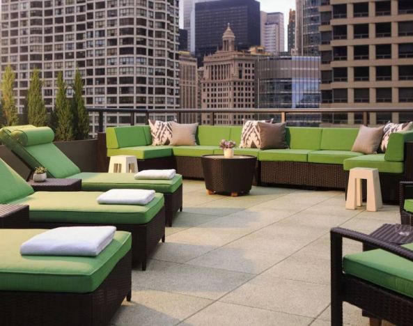 Royal Sonesta Chicago River North’s patio is furnished with chairs, loungers, and sofas, and offers city views.