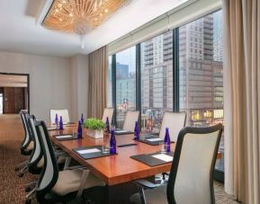 Hotel meeting room, with long wooden table, eight swivel chairs, and floor-to-ceiling windows.