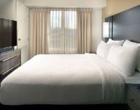 Double bed guest room with a window and large TV at Sonesta ES Suites Raleigh Durham Airport Morrisville.