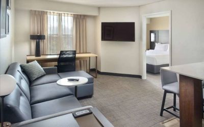 Double bed guest room living area in Sonesta ES Suites Raleigh Durham Airport Morrisville, with sofa, window, and TV.