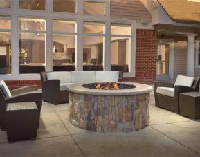 Fire pit surrounded by armchair and sofa seating, plus coffee tables, at Sonesta ES Suites Raleigh Durham Airport Morrisville.