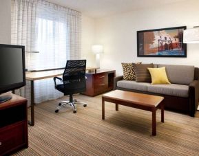 Guest room workspace desk and chair, with TV and sofa nearby, at Sonesta ES Suites San Antonio Downtown Alamo Plaza.