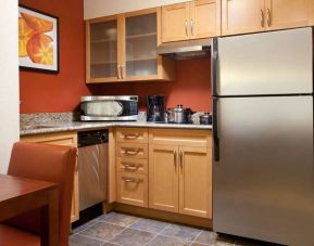 Guest room kitchen fitted with microwave, fridge-freezer, hob, and table at Sonesta ES Suites San Antonio Downtown Alamo Plaza.