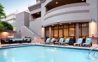 Sonesta ES Suites San Antonio Downtown Alamo Plaza’s outdoor pool has armchair and sofa seating by the side, as well as sun loungers.