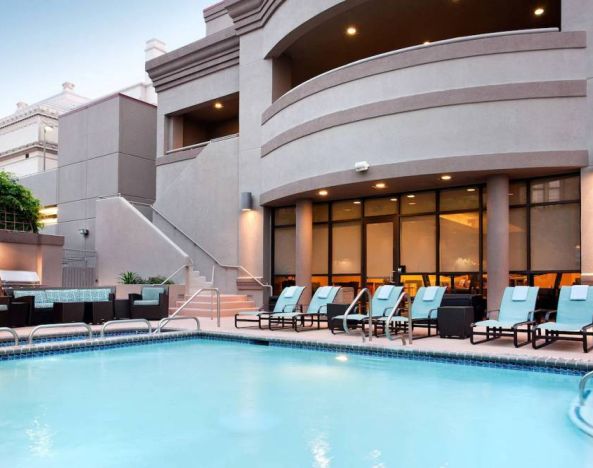 Sonesta ES Suites San Antonio Downtown Alamo Plaza’s outdoor pool has armchair and sofa seating by the side, as well as sun loungers.
