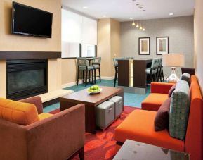 Sonesta ES Suites San Antonio Downtown Alamo Plaza’s lobby lounge has comfy seating, a fireplace, and a wall-mounted TV.