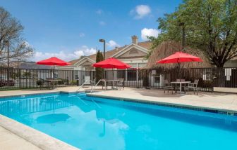 Sonesta ES Suites Reno’s outdoor pool has shaded tables and chairs by the side.