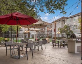 The hotel’s patio area includes shaded tables and chairs alongside barbecue facilities, making it ideal for dining and relaxing.