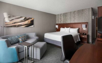 Sonesta Select Los Angeles LAX El Segundo double bed guest room including TV, chair, and sofa.
