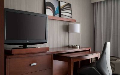 Guest room workspace in Sonesta Select Los Angeles LAX El Segundo, with chair, desk, lamp, and TV.
