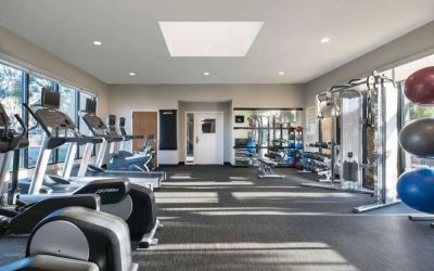 Fitness center equipped with free weights, gym balls, a TV, and various exercise machines at Sonesta Select Los Angeles LAX El Segundo.