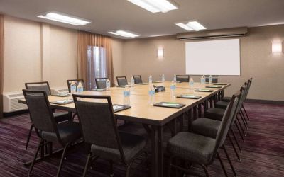 Hotel meeting room, with window, whiteboard, and seating for 14 around a large wooden table.