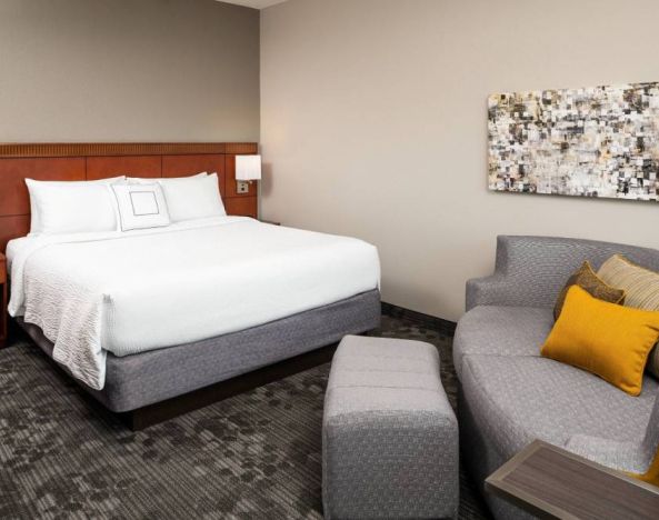 Double bed guest room in Sonesta Select Miami Lakes, featuring art on the wall and a sofa.