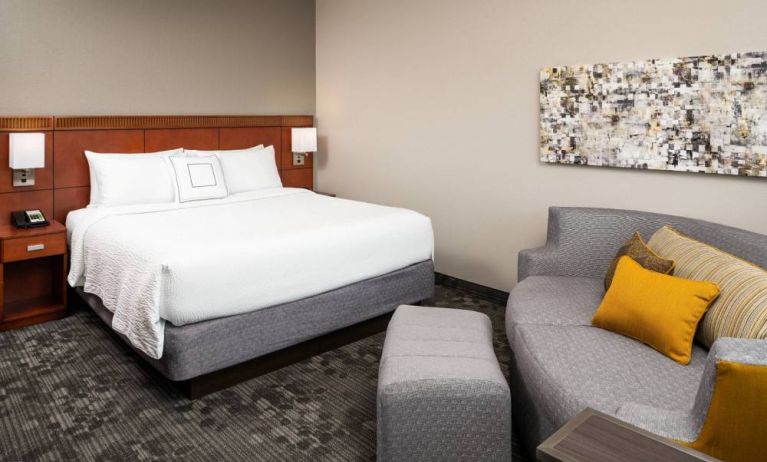 Double bed guest room in Sonesta Select Miami Lakes, featuring art on the wall and a sofa.