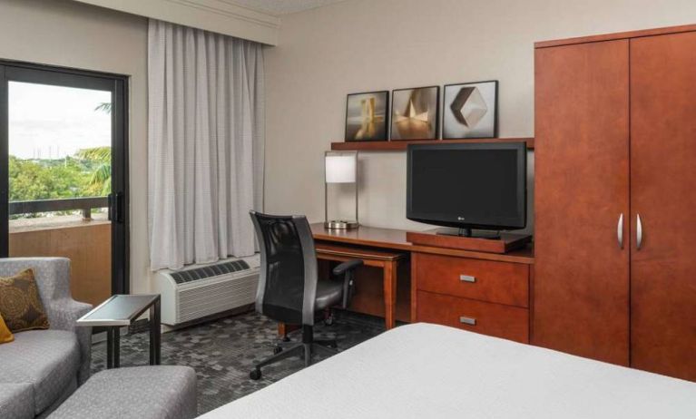 Sonesta Select Miami Lakes’ double bed guest room, with TV and a workspace desk, chair, and lamp.