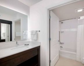 Guest bathroom in Sonesta ES Suites Atlanta Alpharetta North Point Mall featuring shower-equipped bath, lavatory, mirror, and sink.