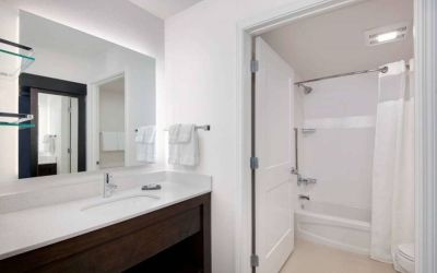 Guest bathroom in Sonesta ES Suites Atlanta Alpharetta North Point Mall featuring shower-equipped bath, lavatory, mirror, and sink.