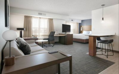 Sonesta ES Suites Fort Worth Fossil Creek double bed guest room, furnished with sofa and TV, plus workspace desk and chair.