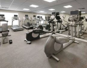 Fitness center at Sonesta ES Suites Fort Worth Fossil Creek, featuring free weights, a mirrored wall, and range of exercise machines.