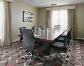 Meeting room in Sonesta ES Suites Fort Worth Fossil Creek, furnished with long wooden table and eight swivel chairs.