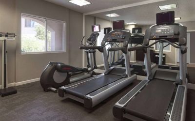 Sonesta ES Suites Tempe’s fitness center has a window, mirrored wall, treadmills, and an elliptical machine.