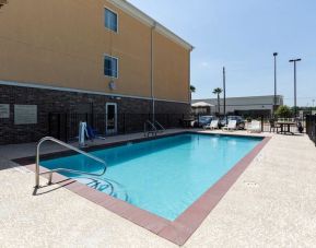 Large outdoor pool with pool chairs at Hotel Pearland.